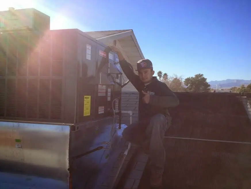 HVAC technician performing Air Duct Repair on a rooftop unit in Clayton
